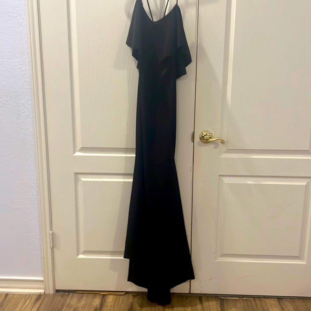 Black evening dress with ruffled back detail and thin straps.